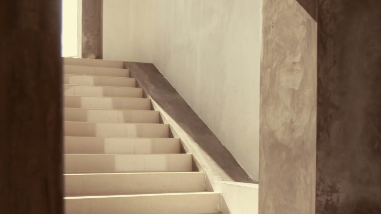 Abstract architectural view of a staircase rising through a concrete interior